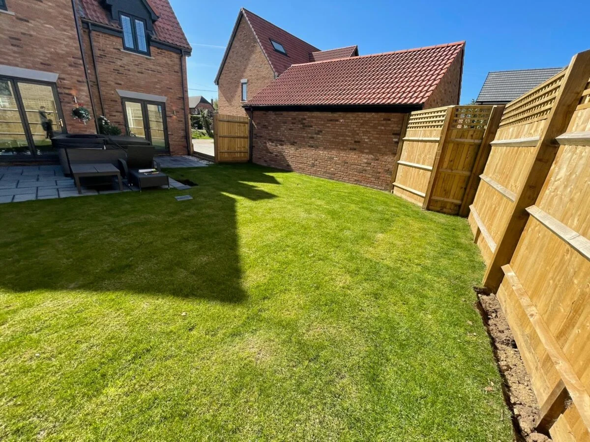Before: Completed back garden with new lawn, grey paving and timber fencing